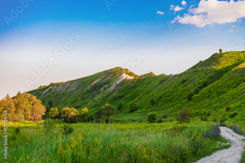 Green chalk hills under blue sky. The multilayered archaeological monument - Krapivinskaya settlement, Belgorod region, Russia. Summer landscape. © nskyr2