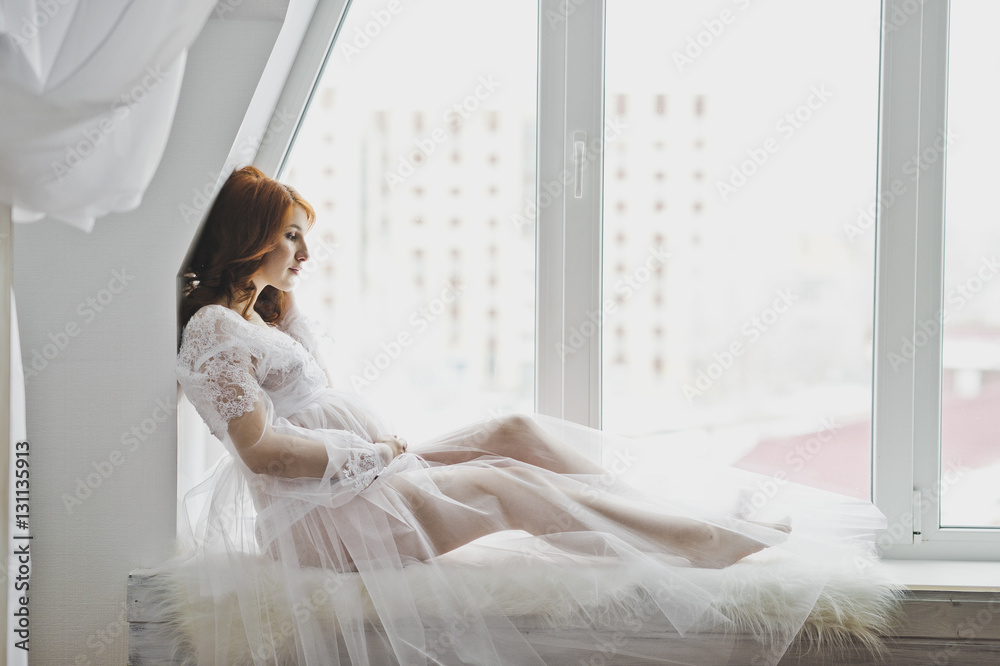 Beautiful girl in a white robe sitting on the windowsill 6867. Beautiful girl in a white robe sitting on the windowsill 6867.