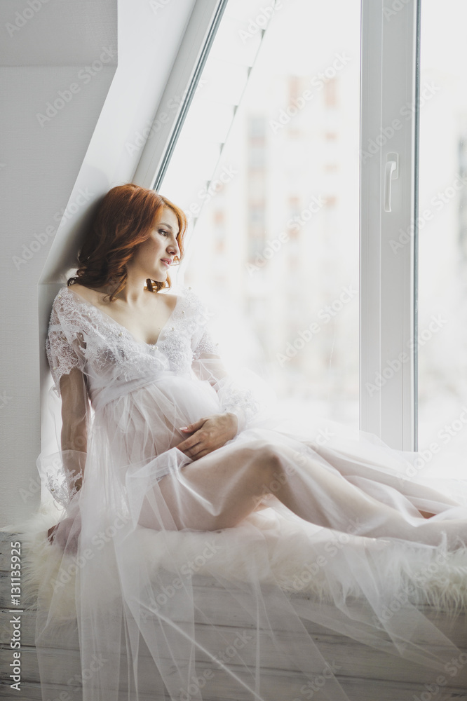 Beautiful girl in a white robe sitting on the windowsill 6869. Beautiful girl in a white robe sitting on the windowsill 6869.
