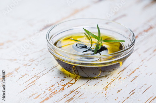 Olive oil with maslines on wood background