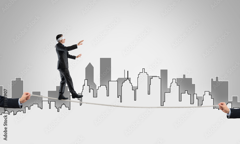 Business concept of risk support and assistance with man balancing on rope Business concept of risk support and assistance with man balancing on rope