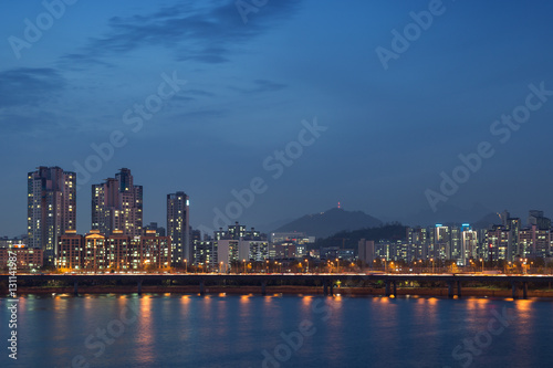 View of a lit residential district and bridge along the Han River in Seoul  South Korea  at night. Copy space.