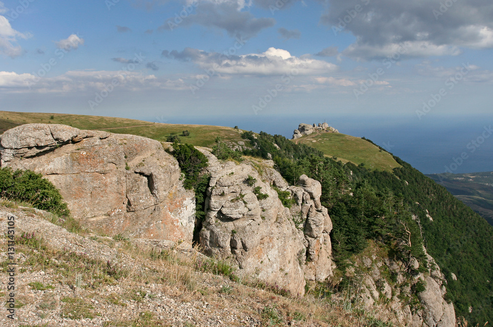 The mountain landscape with sunlit limestone cliffs. This photo was taken in Crimean Mountains, on South Demerdzhi mountain.