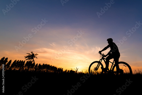 Silhouette the man with mountain bicycle at beautiful sunset