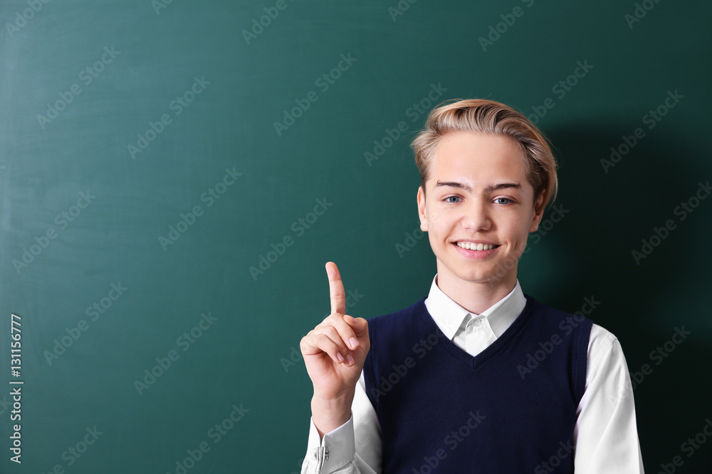 Pupil standing near green school blackboard Pupil standing near green school blackboard