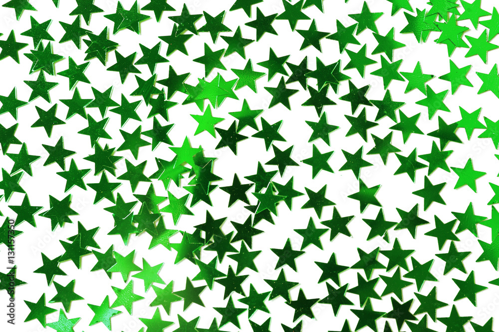 Bright confetti in shape of stars, on green background. Close up Bright confetti in shape of stars, on green background. Close up