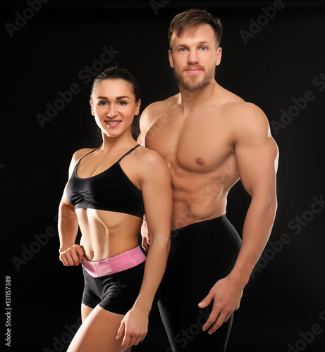 Sporty young couple on black background © Africa Studio