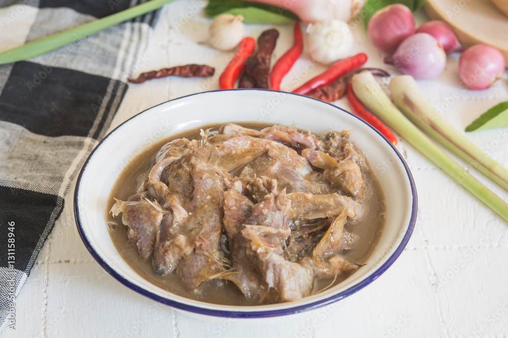 pickles fish in bowl and wood spoon on white food table