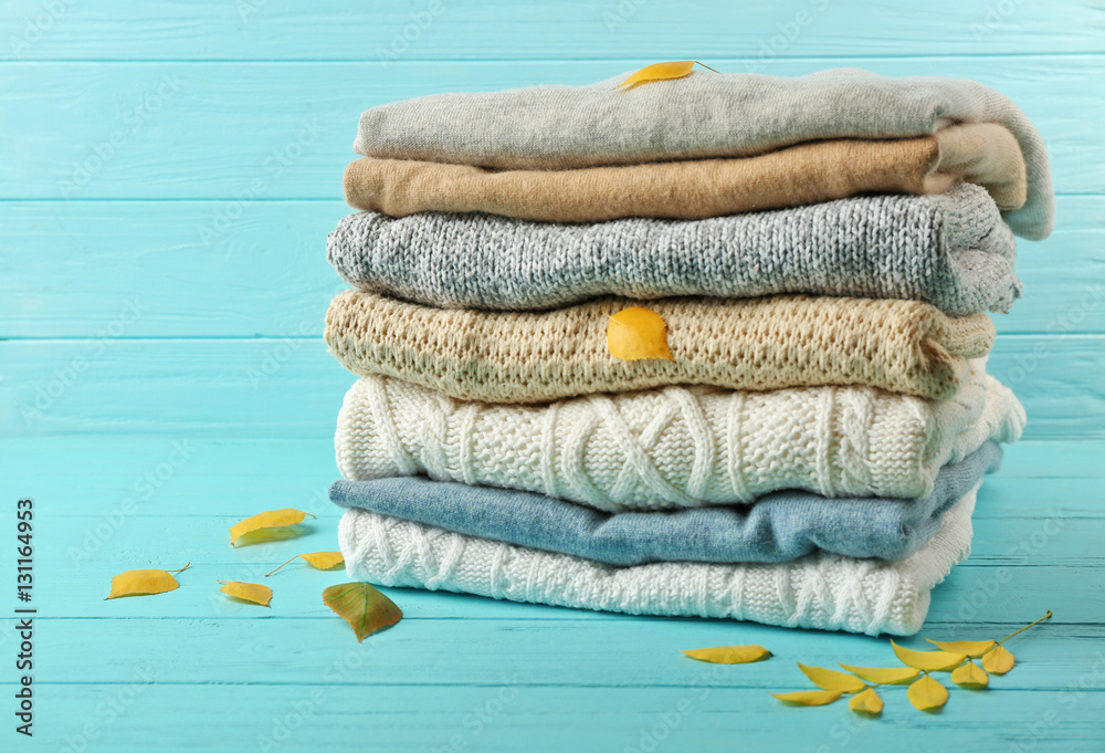 Stack of folded clothes with autumn leaves on wooden background Stock ...