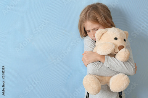 Upset girl with teddy bear ...