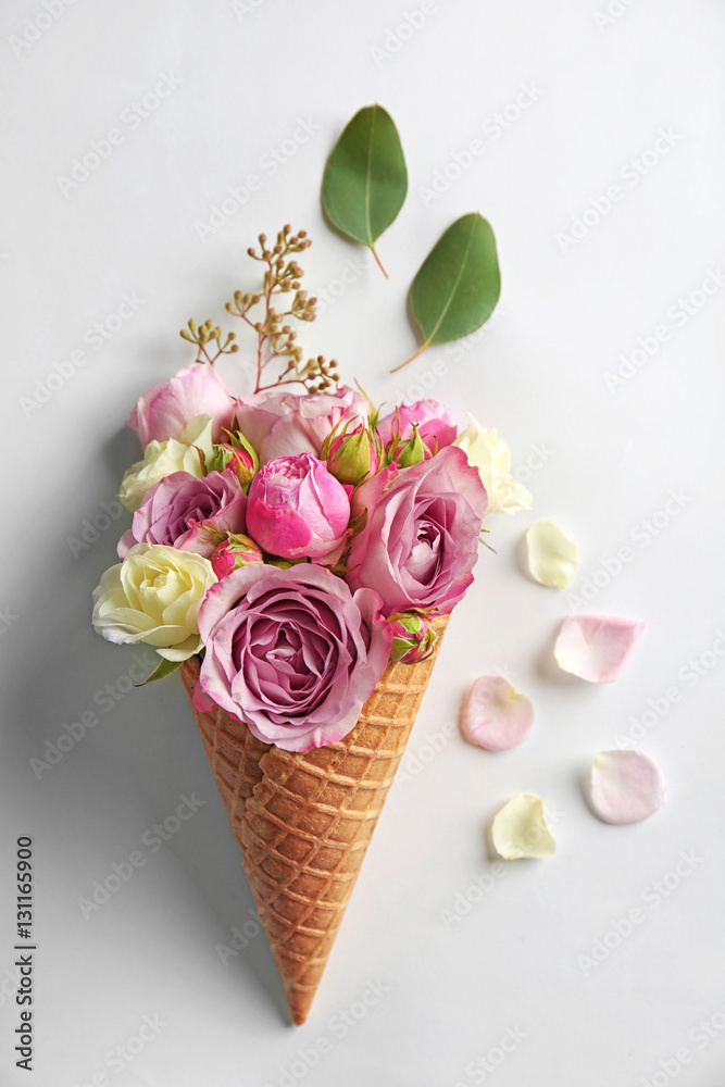 Naklejka premium Waffle cone with composition of flowers and branches on white background