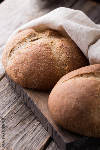 Wholemeal wheat bread on wooden background. Close up