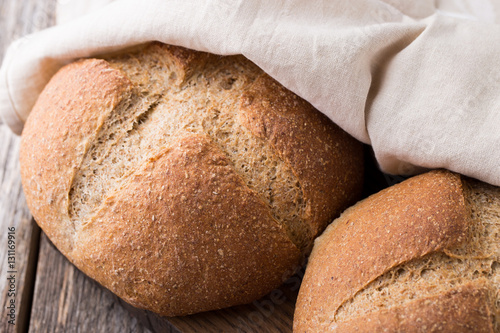 Wholemeal wheat bread on wooden background. Close up