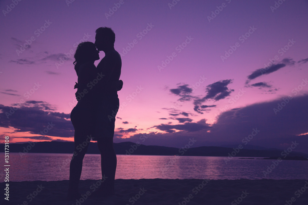 Couple enjoying on the beach in sunset / sunrise time.