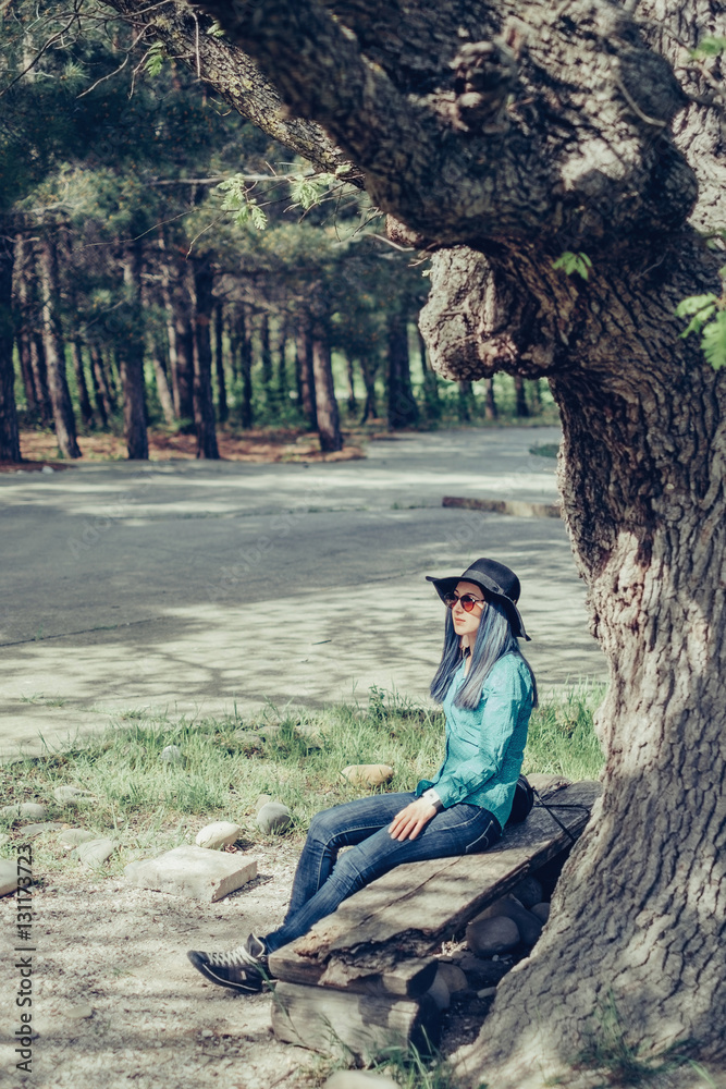 Naklejka premium Woman resting on bench in spring