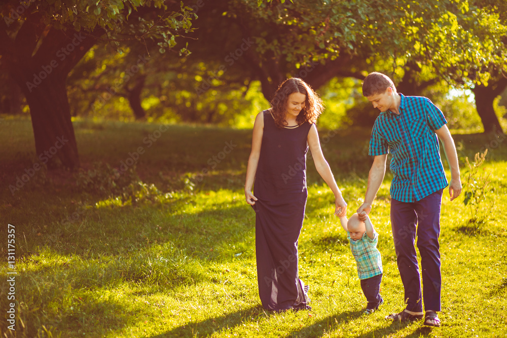 Obraz premium The mother,father and son walking along park