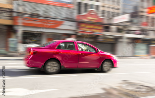 Blur motion concept of pink taxi on the road