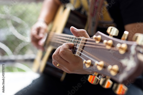 Man Practicing in playing acoustic guitar