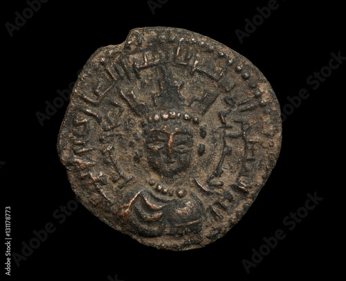 Ancient bronze islamic coin with ruler with crown on his head isolated on black