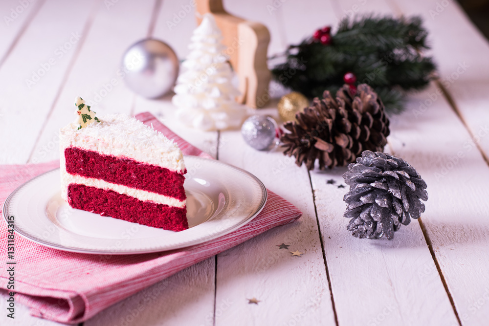 Christmas cake on plate on red fabric on wood background and dec Christmas cake on plate on red fabric on wood background and dec