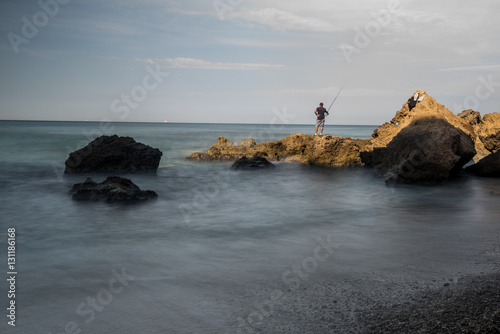 Man standing on rocks fishing, Hadera, israel photo
