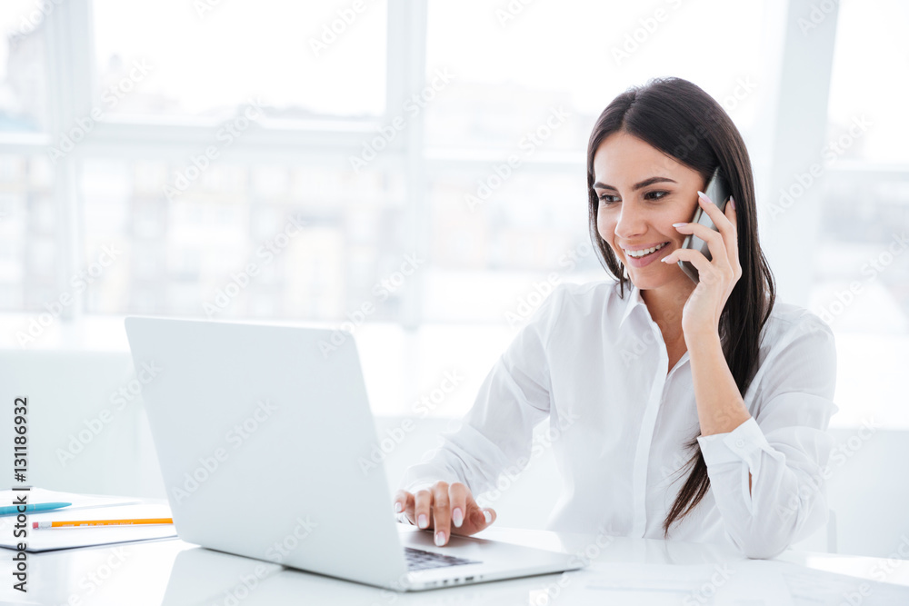 Side view Business woman talking at phone by the table Side view Business woman talking at phone by the table