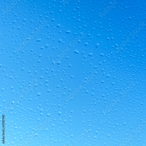 water drops on glass with blue sky background