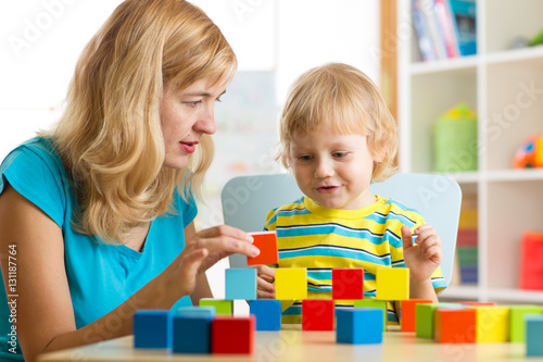 Child together with mother playing educational toys