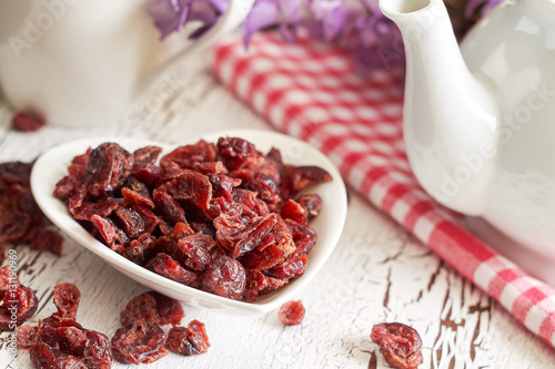 Dried cranberries in white bowl on rustic table