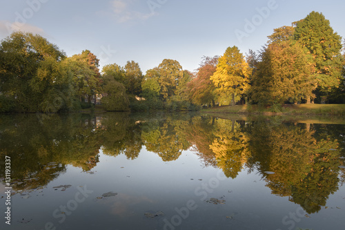Autumn colored trees reflecting in park lake giving beautiful scenery