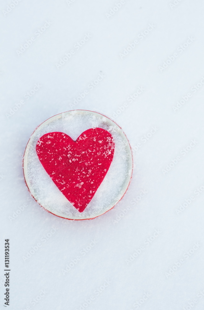 Red felt heart shape in a bowl in snow, Valentine's Day. Copy space for text. Snowflakes on heart. Valentines day, love concept. White background