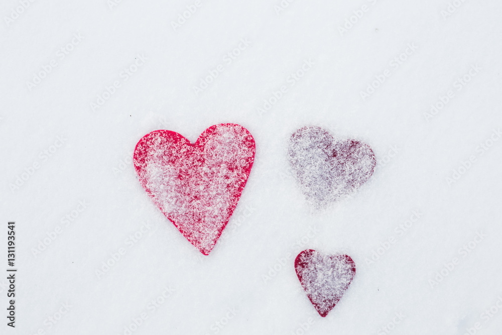 Three red felt heart shapes in snow, Valentine's Day. Copy space for text. Snowflakes on hearts. Valentines day, love concept. White background Three red felt heart shapes in snow, Valentine's Day. Copy space for text. Snowflakes on hearts. Valentines day, love concept. White background