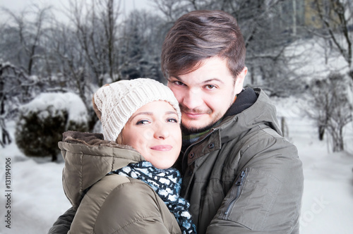 Couple smiling and hugging each other in winter forest
