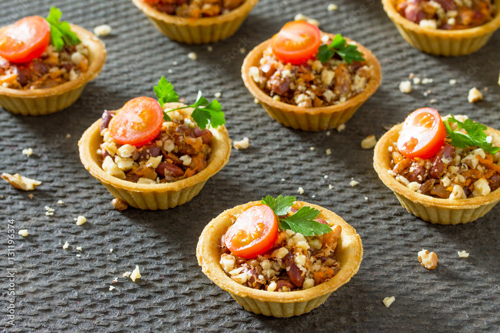 Holiday appetizer: tartlet with beans, meat and walnuts on a fes
