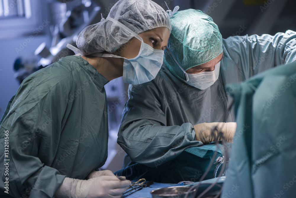 Neurosurgeon with nurse closing operation wound Neurosurgeon with nurse closing operation wound