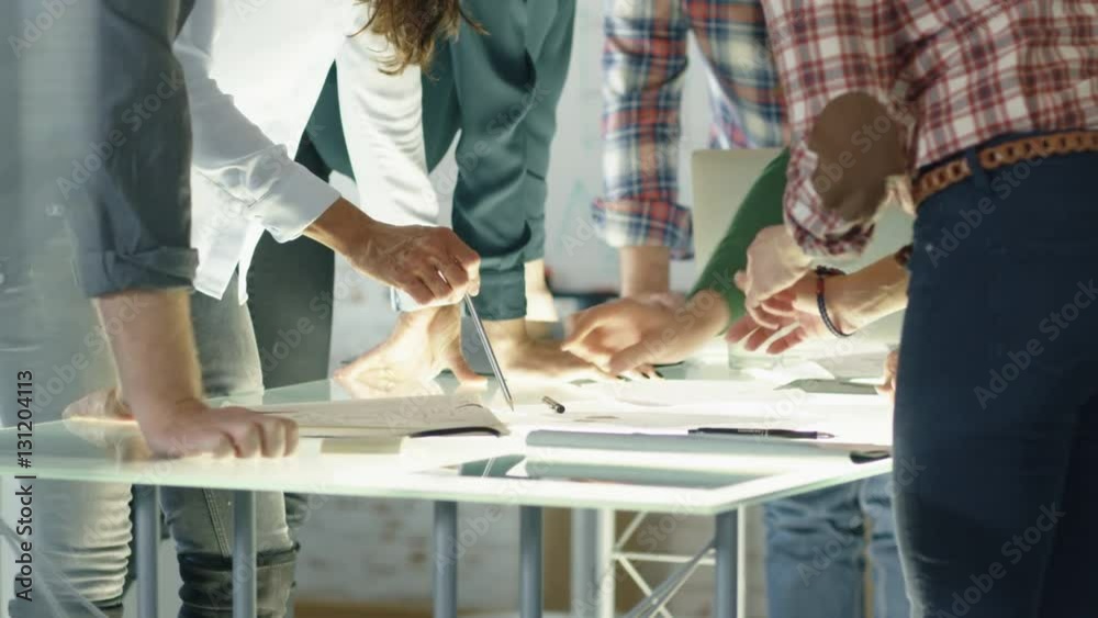 In Creative Bureau. Close Shot of a Busy Glass Conference Table  and  Coworkers Leaning on it in Collective Leap to Find Problem Solutions.  Shot on RED EPIC (uhd).