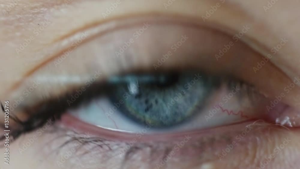 Macro shot of blue female eye with animated blue circles illustrating laser therapy