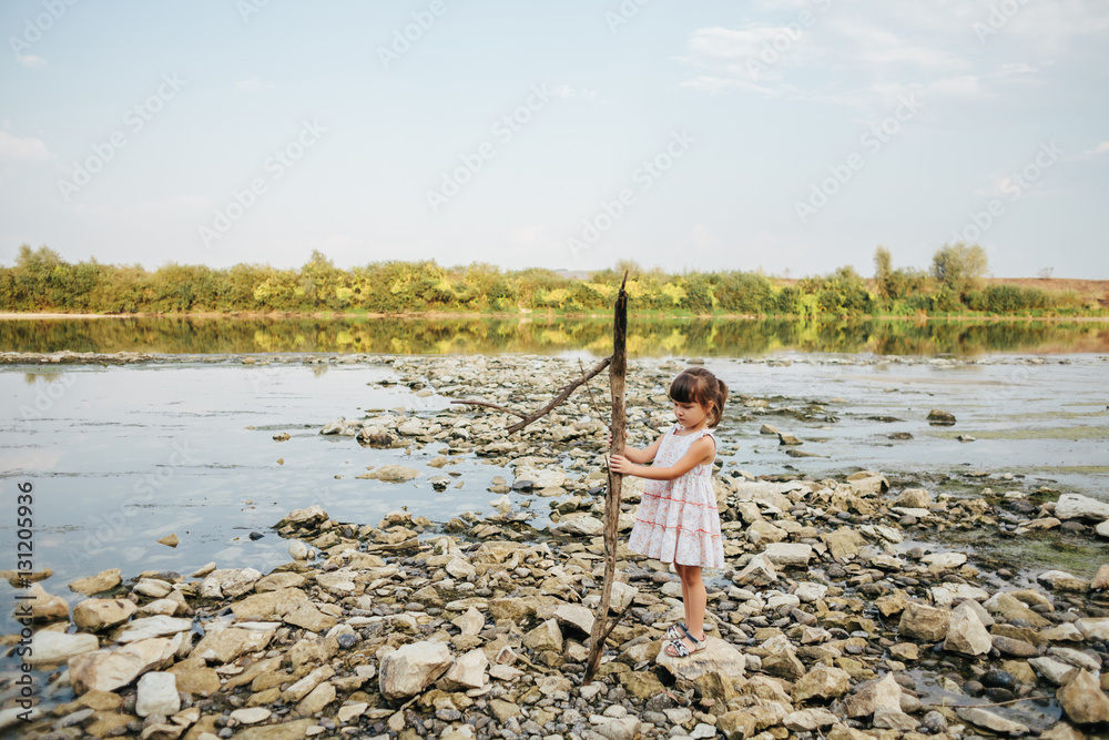 Fototapeta premium girl holding a dry branch of the river