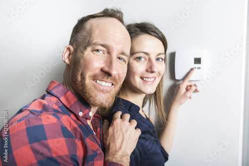 Couple set the thermostat at home photo