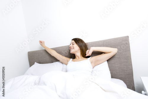 Young sleeping woman in bedroom at home wearing in white