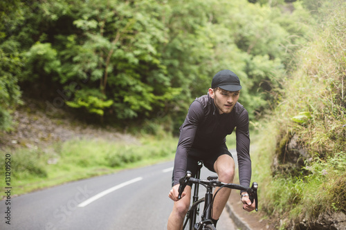 A young road cyclist dressed in black, enjoying a ride in Chedda