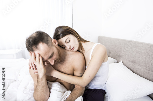 young couple in bed with relation problems