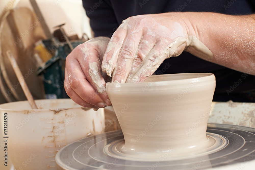 Close Up Of Potter Moulding Clay On Wheel