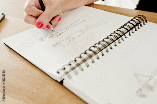 Cropped view of woman sketching fashion design