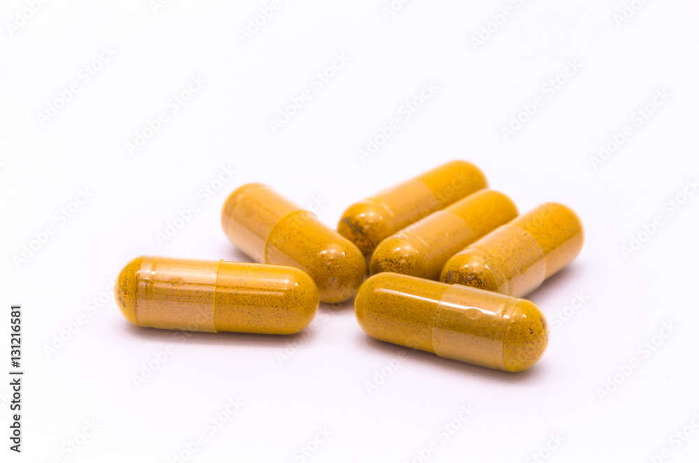 Turmeric powder with herbal capsule on white background. Turmeric powder with herbal capsule on white background.