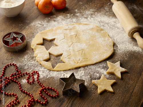 Table with christmas star biscuit dough and rolling pin