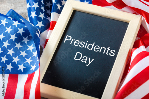 the text happy presidents day written in a chalkboard and a flag of the United States