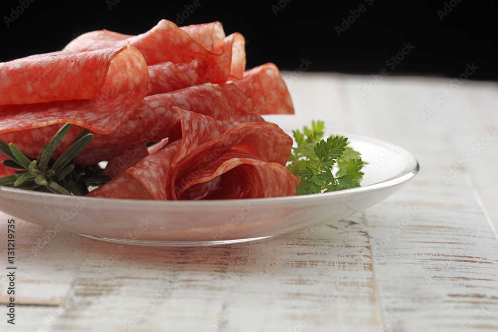 Slices of salami sausage on wooden table. Selective focus