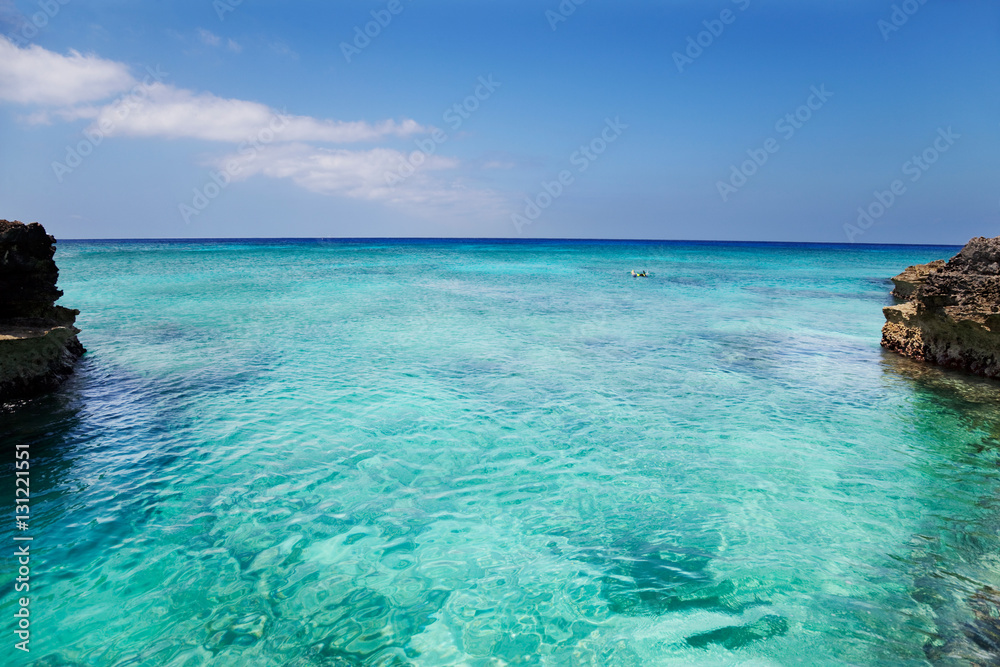 Man explores the reef off Smith Cove, Grand Cayman. Slight curve to the horizon