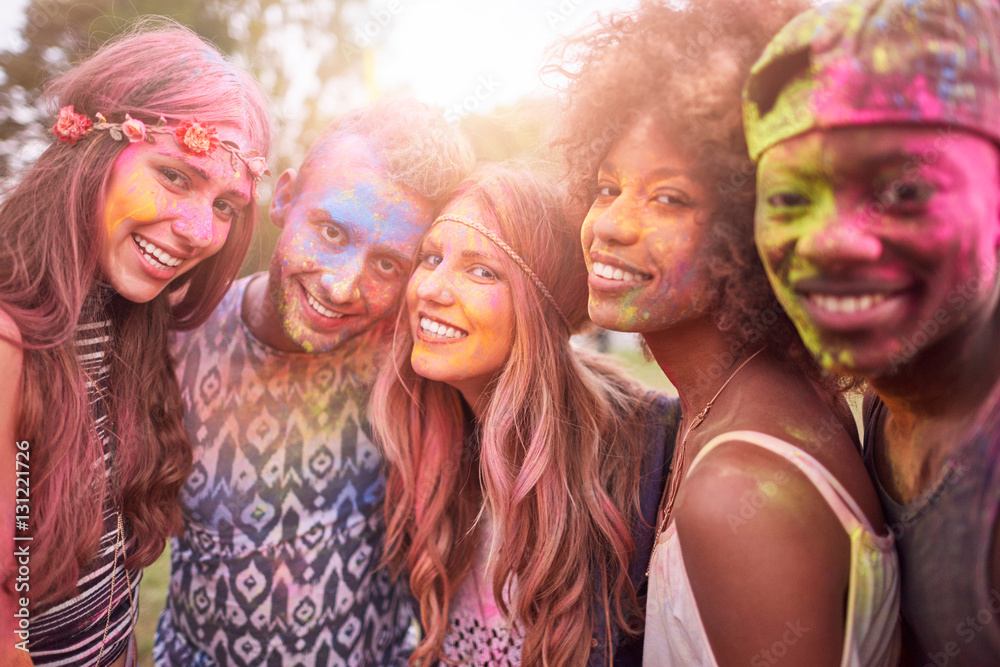 Portrait of group of friends at festival, covered in colourful powder paint Portrait of group of friends at festival, covered in colourful powder paint